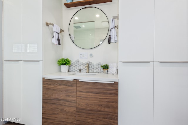 bathroom with vanity and tasteful backsplash