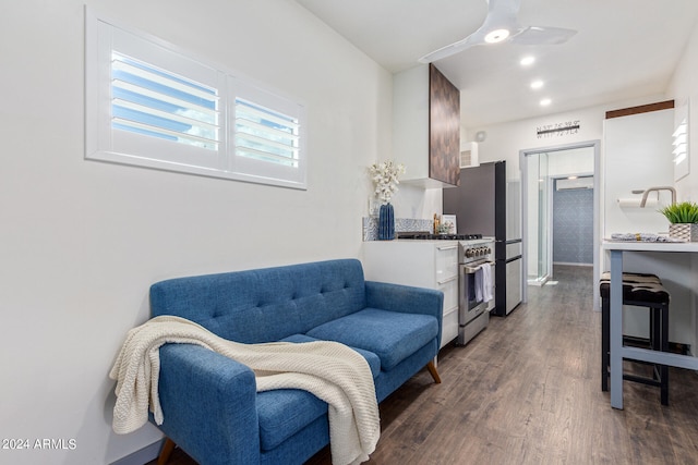 living room featuring ceiling fan and dark wood-type flooring