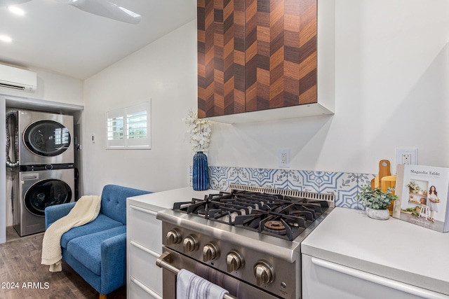 kitchen featuring dark wood-type flooring, high end stainless steel range, an AC wall unit, stacked washer / drying machine, and ceiling fan