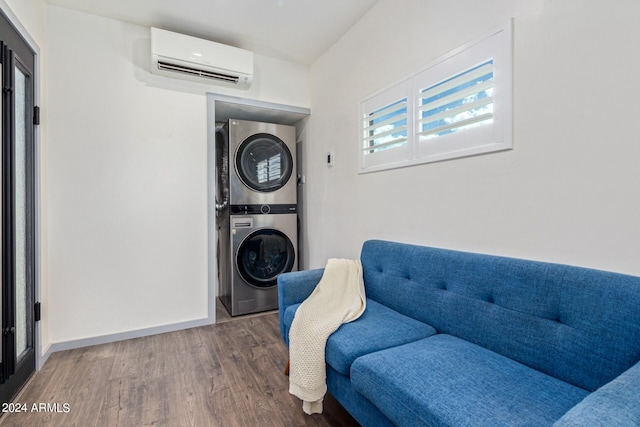 living area featuring wood-type flooring, stacked washer and dryer, and a wall unit AC