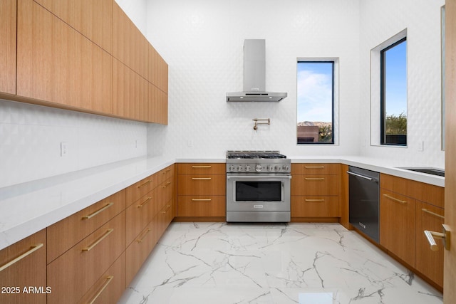 kitchen featuring appliances with stainless steel finishes, sink, wall chimney range hood, and decorative backsplash