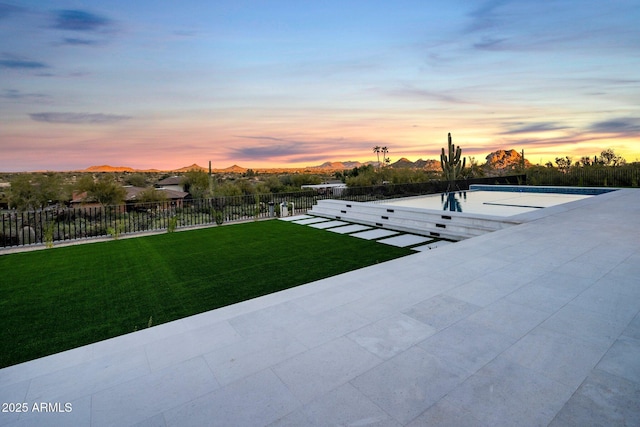 yard at dusk with a patio area