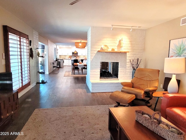 202 N Florence Ave, Litchfield Park, AZ 85340 - living room with dark wood finished floors, rail lighting, and a brick fireplace