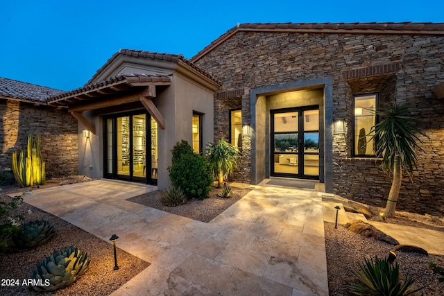 property entrance with a patio and french doors