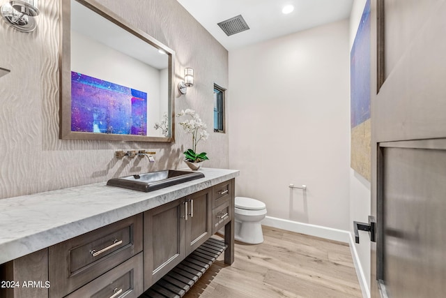 bathroom featuring hardwood / wood-style floors, vanity, and toilet