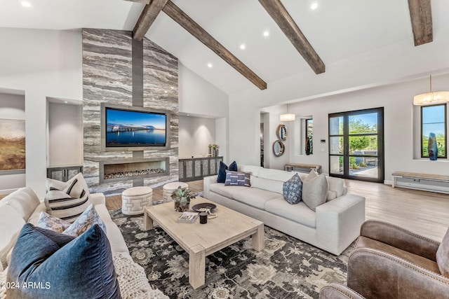 living room with high vaulted ceiling, beamed ceiling, hardwood / wood-style flooring, and a premium fireplace