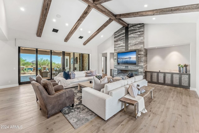 living room featuring a large fireplace, beam ceiling, light wood-type flooring, and high vaulted ceiling