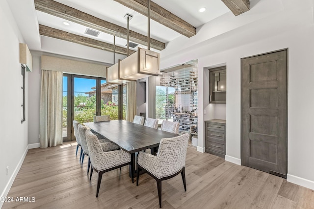 dining space featuring beamed ceiling and light hardwood / wood-style flooring