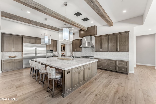 kitchen with beamed ceiling, wall chimney exhaust hood, backsplash, and appliances with stainless steel finishes