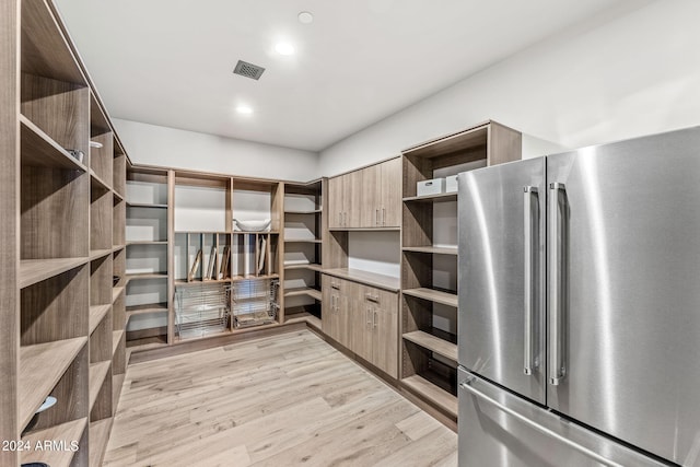 interior space featuring stainless steel fridge and light hardwood / wood-style flooring