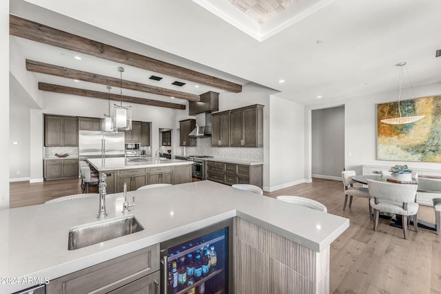 kitchen with light wood-type flooring, sink, an island with sink, and wine cooler