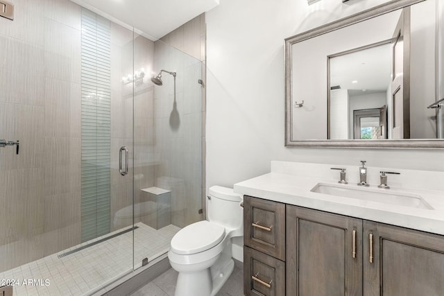 bathroom with a shower with door, vanity, toilet, and tile patterned flooring