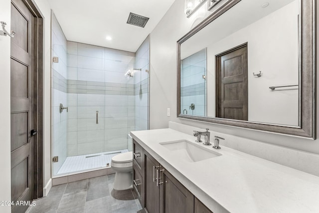 bathroom featuring toilet, vanity, and a shower with shower door