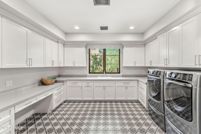 laundry area with cabinets, separate washer and dryer, and sink