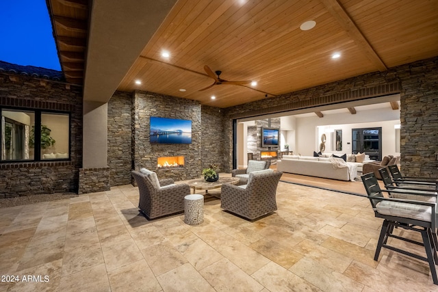 view of patio / terrace with an outdoor living space with a fireplace and ceiling fan