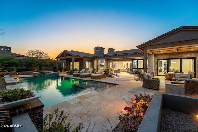 pool at dusk featuring a patio and an outdoor hangout area