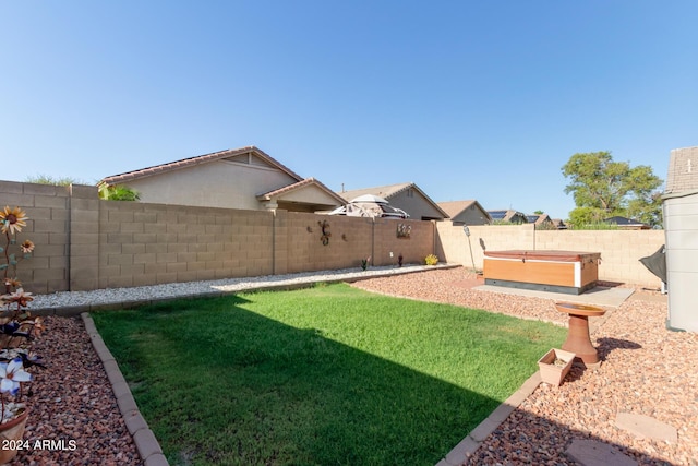 view of yard featuring a hot tub and a fenced backyard