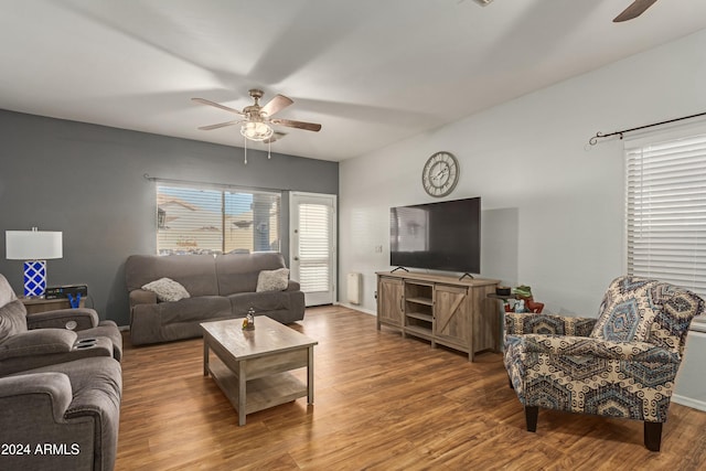 living area featuring wood finished floors, a ceiling fan, and baseboards