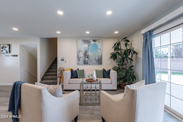 living room with baseboards, stairway, light wood finished floors, and recessed lighting