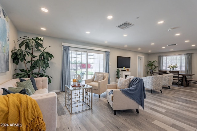 living room with light wood finished floors, visible vents, and recessed lighting