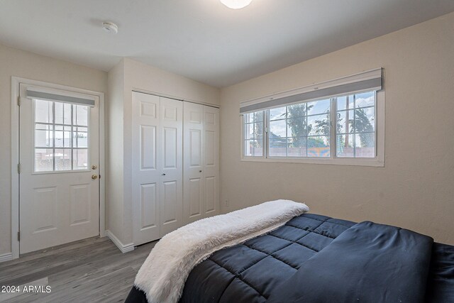 bedroom featuring baseboards, a closet, and wood finished floors