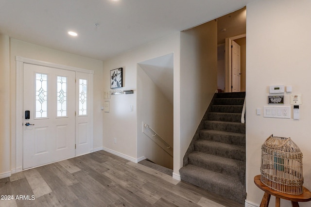 entryway with recessed lighting, baseboards, stairway, and wood finished floors