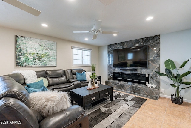 tiled living room with a high end fireplace and ceiling fan