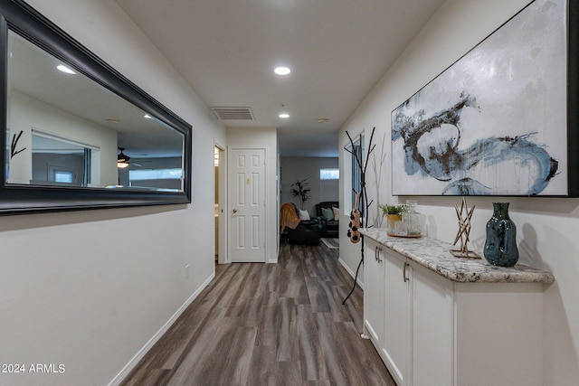 hall featuring dark wood-style flooring, recessed lighting, baseboards, and visible vents