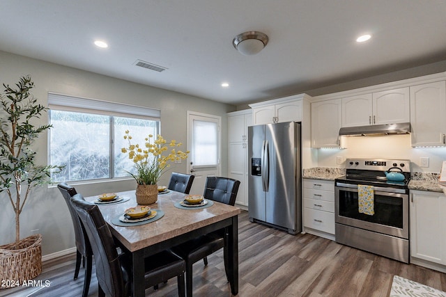 kitchen with white cabinets, stainless steel appliances, dark hardwood / wood-style flooring, and light stone countertops