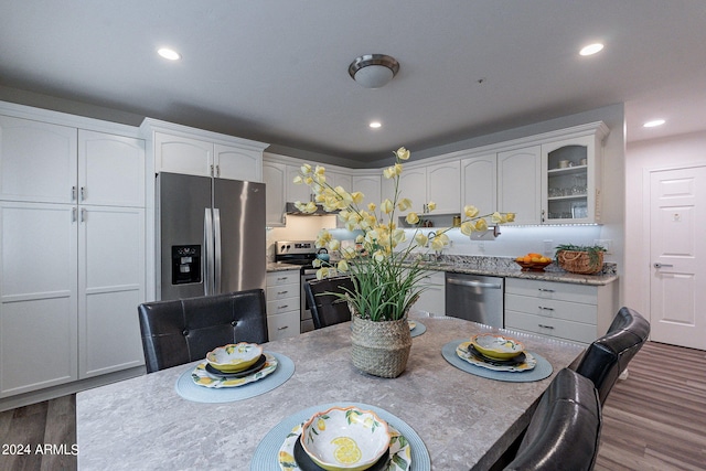 dining area with wood finished floors and recessed lighting