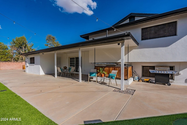back of property with stucco siding and a patio
