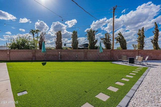 view of yard featuring fence and a patio