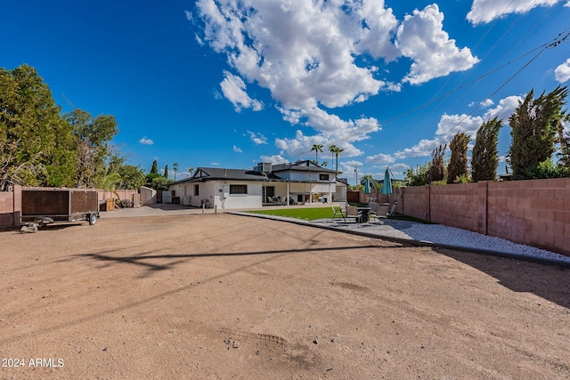 rear view of house featuring a fenced backyard and a patio