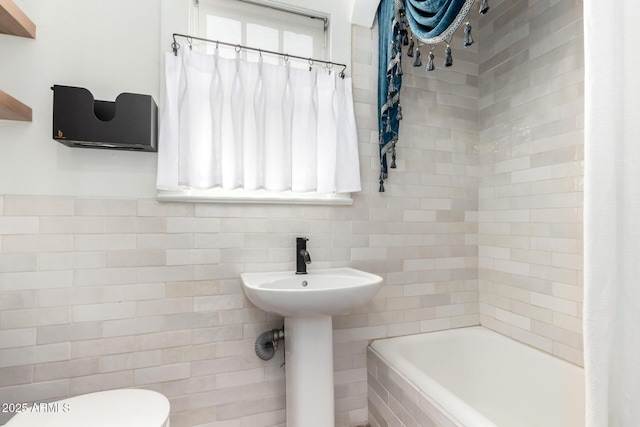 full bathroom featuring sink, toilet, shower / tub combo, and tile walls