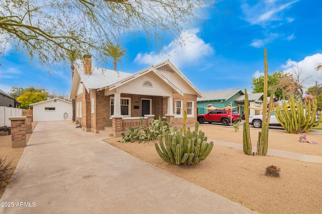 view of front of home featuring a garage, an outbuilding, and a porch