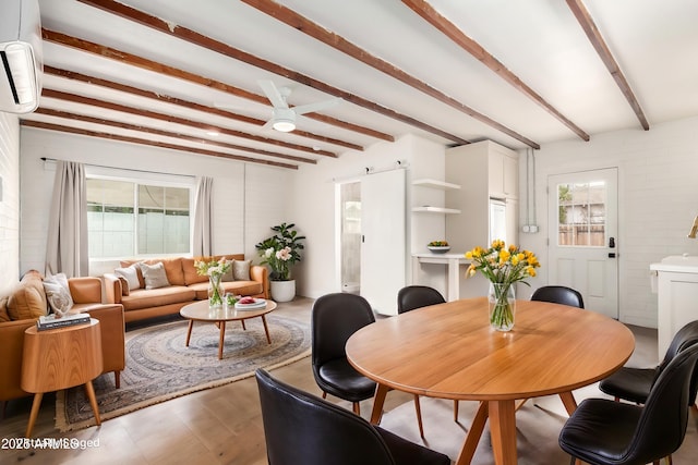 dining space featuring a healthy amount of sunlight, beamed ceiling, and a wall mounted AC