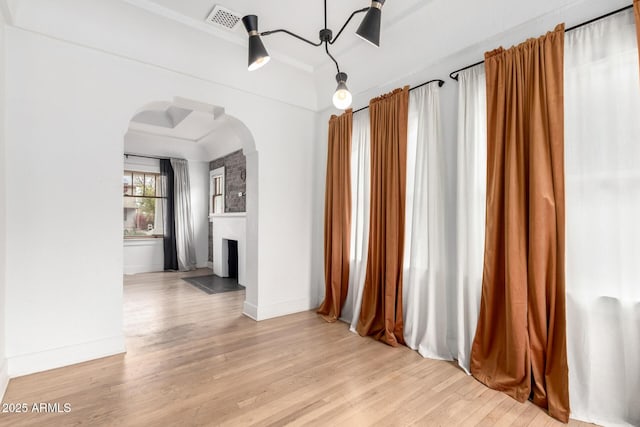 interior space featuring crown molding, a fireplace, and light hardwood / wood-style flooring