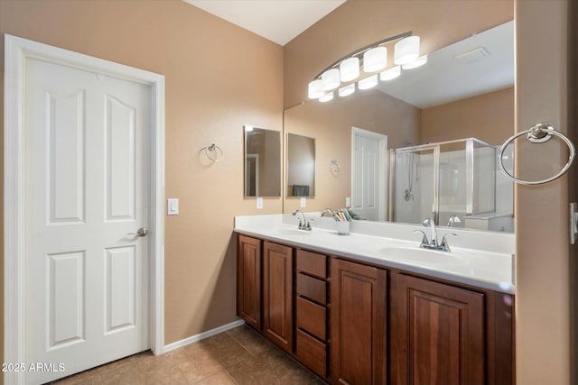 full bath with tile patterned flooring, double vanity, a sink, and a stall shower
