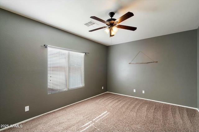 spare room with baseboards, carpet, a ceiling fan, and visible vents