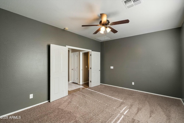 unfurnished bedroom featuring baseboards, visible vents, and carpet