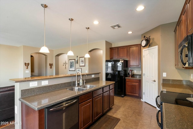 kitchen featuring visible vents, a sink, a kitchen island with sink, arched walkways, and black appliances