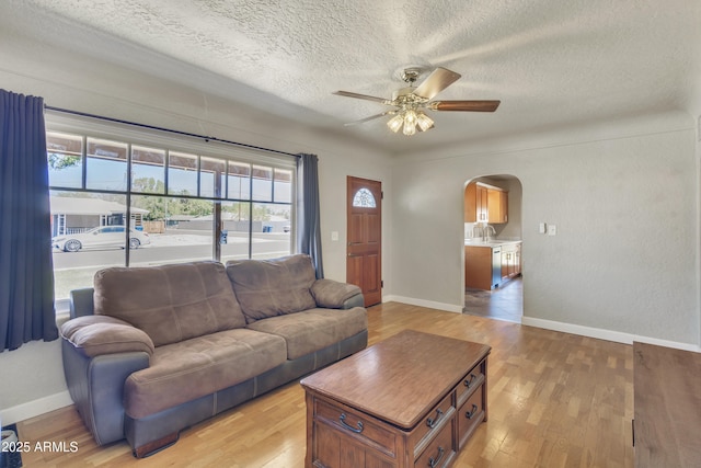 101 W 8th Pl, Mesa, AZ 85201 - living area with light wood-style floors, arched walkways, a textured ceiling, and a ceiling fan
