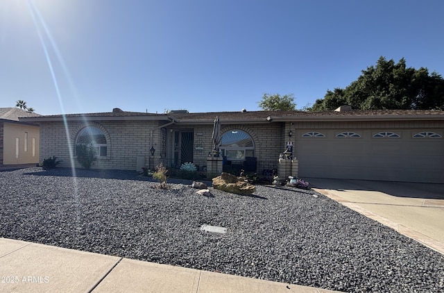 ranch-style home featuring a garage, concrete driveway, and brick siding