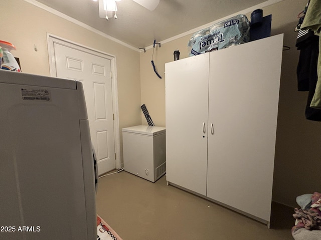 laundry area featuring ceiling fan, cabinet space, and crown molding