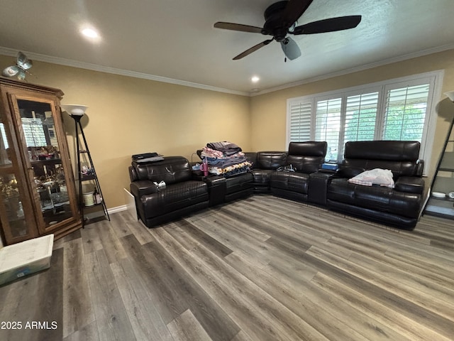 living area featuring ceiling fan, ornamental molding, wood finished floors, and baseboards