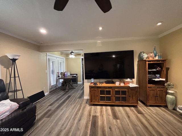 living area featuring recessed lighting, wood finished floors, a ceiling fan, baseboards, and crown molding