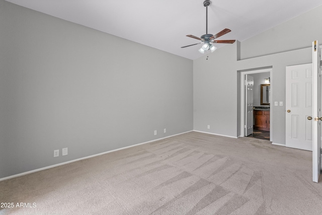 unfurnished bedroom with carpet floors, baseboards, ensuite bath, and lofted ceiling