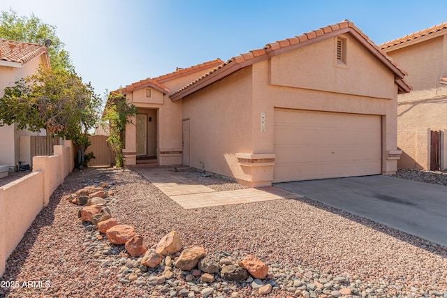 view of front of house with driveway, stucco siding, fence, and a garage