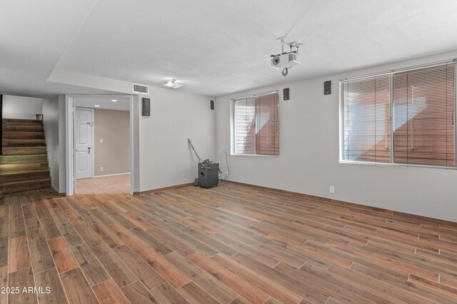 below grade area with stairway, visible vents, baseboards, and wood finished floors