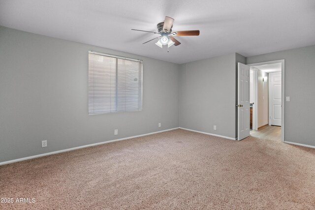 unfurnished room featuring baseboards, a ceiling fan, and light colored carpet